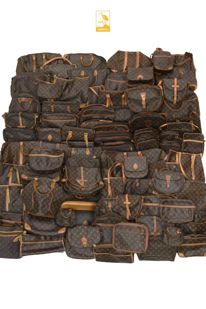 Lot de plusieurs dizaines de sacs Louis Vuitton en toile Monogram de seconde main, disposés à plat sur fond blanc sous le logo EGRETTA.